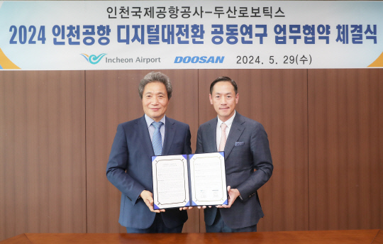 박인원(오른쪽) 두산로보틱스 대표와 이학재 인천국제공항공사 사장이 지난 29일 인천국제공항에서 '디지털 전환 추진 협업 체계 구축' 업무협약 후 기념사진을 촬영하고 있다. 두산로보틱스 제공
